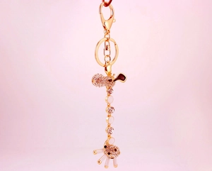 Detailed view of a gold giraffe keychain featuring sparkling rhinestones and white enamel