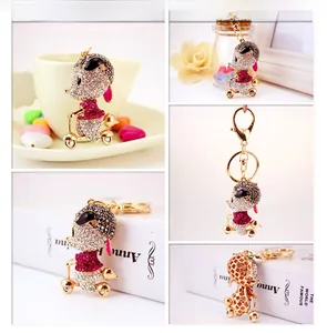 Multi-angle views of a rhinestone-encrusted mouse scooter keychain in gold-tone metal