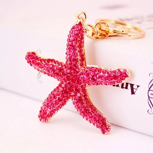 Sparkling starfish keychain with rose red rhinestones and golden metal hardware