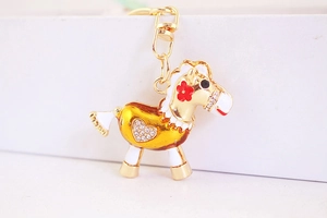 Détail du porte-clés cheval doré avec émail jaune, strass et fermoir mousqueton