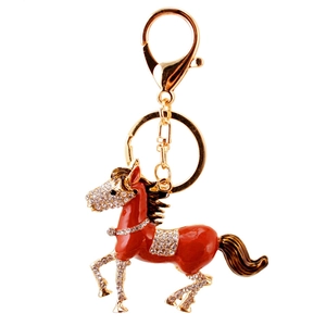 Golden horse keychain with red enamel and sparkling crystal rhinestones on white background