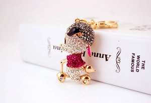 Detailed macro view of a rhinestone-studded mouse figurine on a scooter keychain