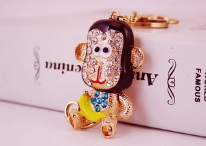 Détail du porte-clés singe en cristal avec strass bleus et petite banane jaune