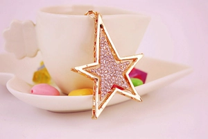 Vue détaillée d'un pendentif étoile dorée avec strass sur le bord d'une tasse
