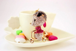 Macro view of crystal encrusted mouse figurine on a scooter with pink rhinestones