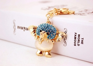 Macro shot of gold elephant keychain with blue rhinestones and white opal stone inlay