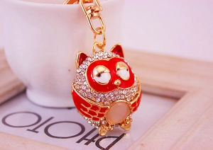 Close-up of owl keychain with red enamel, crystal rhinestones, and cat eye stone detail