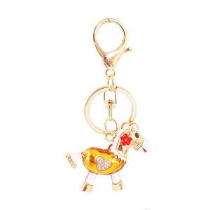 Gros plan détaillé du porte-clés cheval doré avec fleur rouge et cœur en strass brillant