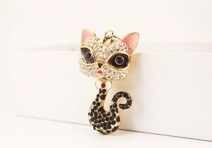 Vue macro d'un pendentif chat doré avec des strass étincelants et de l'émail rose