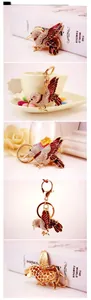 Detail of red enamel bird keychain with crystals and golden metal hollow back structure