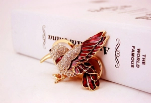 Detailed close-up of hummingbird keychain with red enamel and sparkling crystal accents