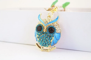Close-up of blue crystal owl keychain with gold plating and sparkling rhinestone details