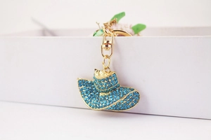 Detailed close-up of a blue rhinestone encrusted sun hat keychain with golden clasp