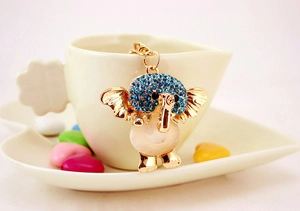Detail of elephant keychain with blue rhinestones and pink opal hanging on a cup