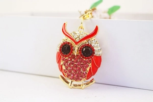 Close-up of cute cartoon owl keychain with red rhinestones and golden alloy plating