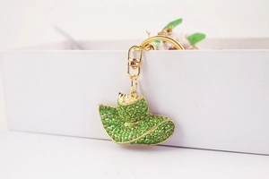 Detail of creative cowboy hat keychain with green rhinestones and golden metal hardware