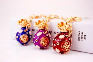 Detailed macro view of colorful enamel lucky bag keychains with sparkling crystals and gold accents