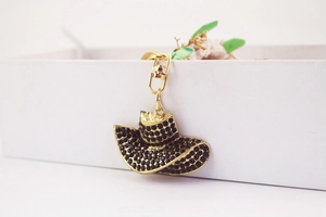 Detail shot of mini cowboy hat keychain with black rhinestones and gold plating