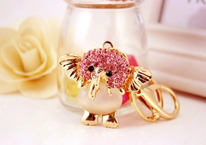 Close-up of golden elephant keychain with pink rhinestones and opal-style stone detail