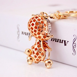 Cute golden bird riding a scooter keychain with sparkling crystals for bags