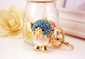 Detail of golden elephant keychain with blue rhinestones and pink cat eye stone decoration