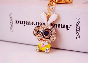 Detailed macro view of a sparkling rhinestone rabbit keychain with golden metal clasp