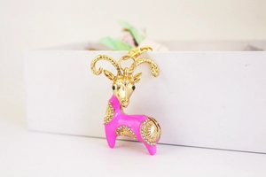 Detail of goat keychain with pink enamel, golden metal base and sparkling rhinestones