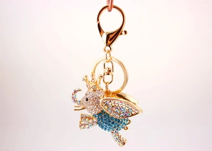 Close-up of golden elephant keychain with sparkling blue rhinestones and crown