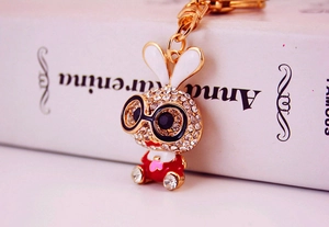 Close-up of golden bunny keychain with sparkling white rhinestones and a red outfit