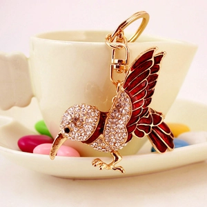 Charming golden hummingbird keychain with sparkling crystals and red enamel detailing