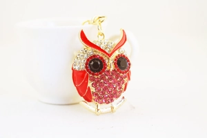 Close-up of owl keychain featuring red rhinestones and black gem eyes on gold metal