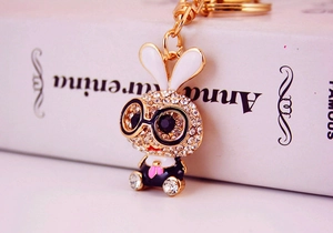 Macro view of crystal rabbit keychain with gold finish and black frame glasses detail