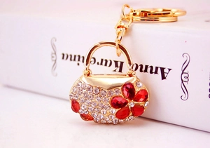 Detailed macro view of handbag-shaped key ring with sparkling crystals and red flower
