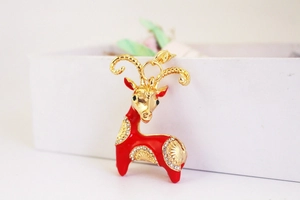 Close-up of red enamel goat keychain with white rhinestones and gold lobster clasp