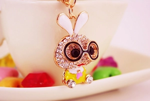 Macro view of cute gold-toned bunny keychain featuring sparkling rhinestones and black glasses