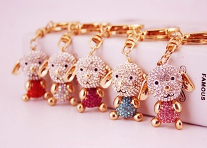 Lot de porte-clés chiot en strass de différentes couleurs sur un fond rose élégant