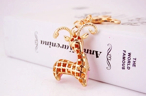 Macro shot of gold-plated giraffe keychain with hollow clover pattern on a book