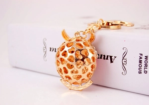 Detailed macro view of the gold hollow heart sphere keychain with horn decoration