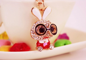 Macro shot of cute cartoon rabbit keychain with sparkling rhinestones and golden metal ring