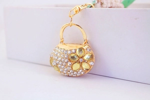 Detailed macro of golden handbag keychain with sparkling crystals and yellow floral gems