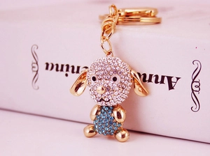Gros plan détaillé d'un porte-clés chien doré orné de strass brillants bleus et blancs