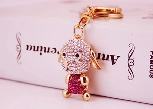 Gros plan d'un porte-clés chien mignon avec strass roses et blancs et anneau doré