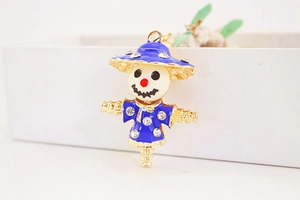 Detailed close-up of a creative crystal-encrusted scarecrow keychain with blue enamel work