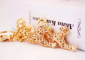 Close-up of gold-plated hollow leopard keychain with rhinestones on a vintage book