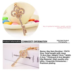 Macro detail of gold-plated crown key keychain with white rhinestones and dimensions