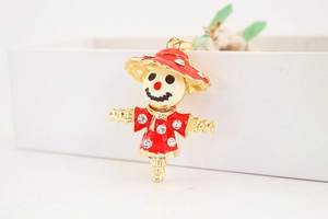 Close-up of scarecrow keychain with red enamel and sparkling rhinestones detailing