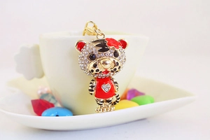 Détail d'un porte-clés tigre mignon avec strass accroché sur une tasse à thé en céramique