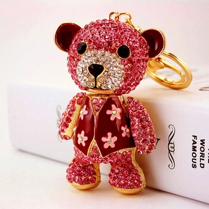 Sparkly pink rhinestone teddy bear keychain with gold metal clip and flower vest detail