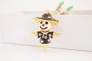 Macro shot of a cute scarecrow metal keychain with rhinestones and enamel finish