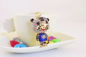 Détail d'un porte-clés tigre mignon avec strass blancs et émail bleu sur une tasse
